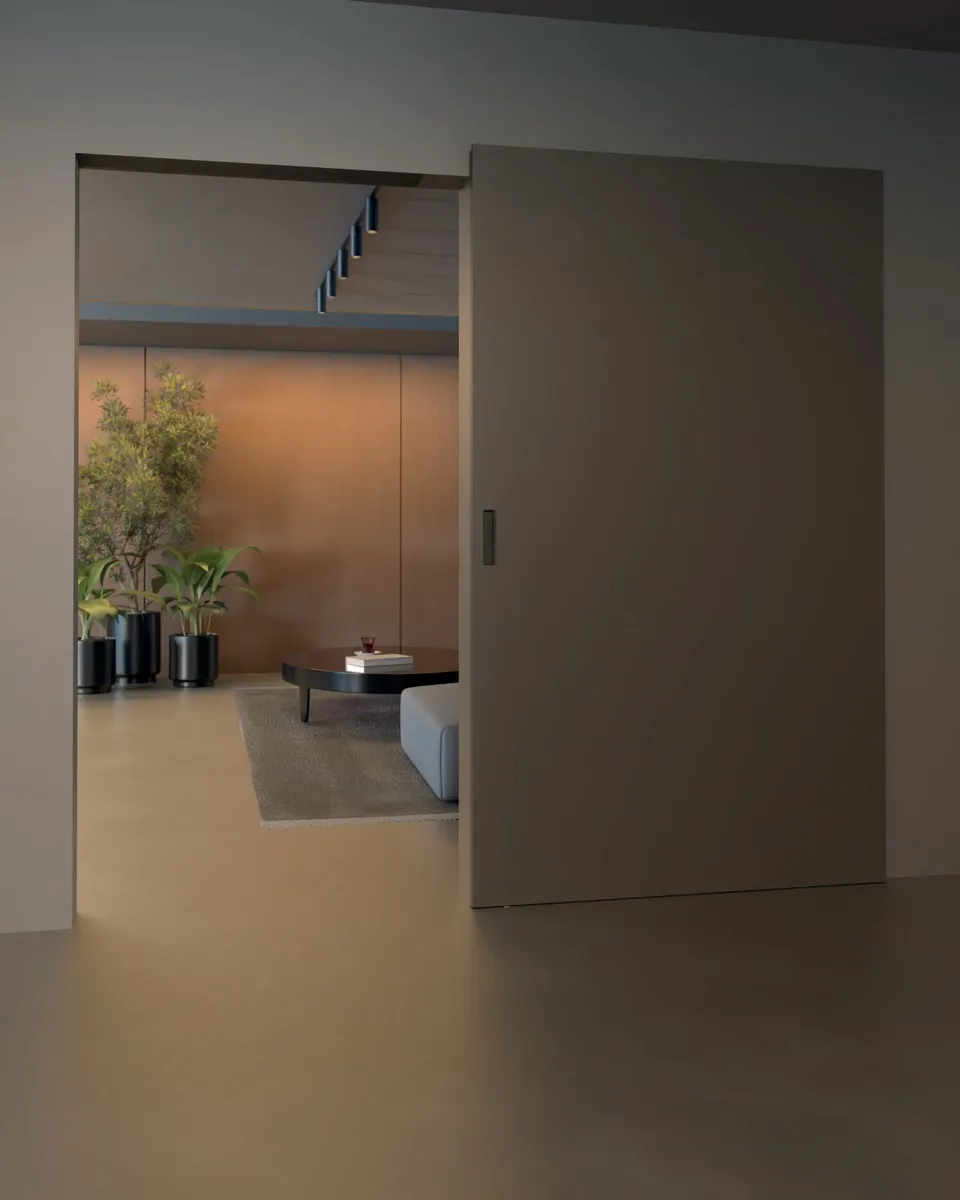 Puerta corrediza gris que separa un pasillo de un living, colgada de un riel que no se ve.